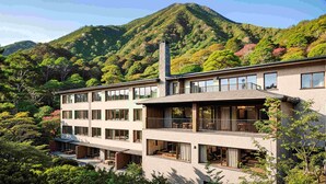 A multi-story building with large windows, a balcony, and a view of a mountainous landscape. - ANDO HOTEL RETREAT HAKONEGOURA (Hakone)