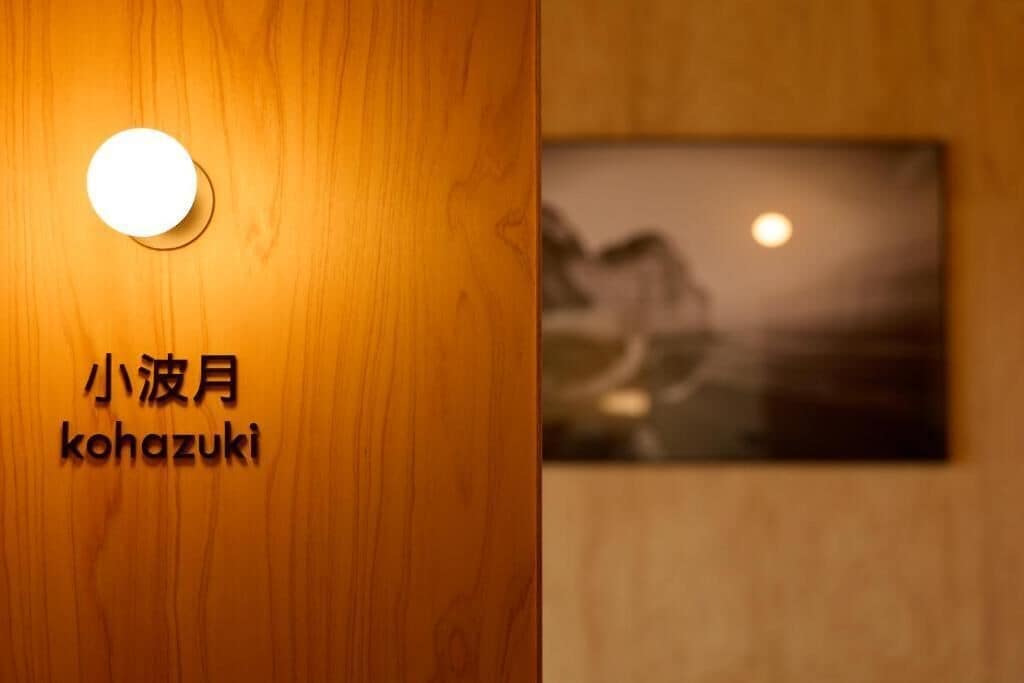 A wooden wall with a round light fixture and a sign with Japanese characters.
