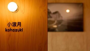 A wooden wall with a round light fixture and a sign with Japanese characters.