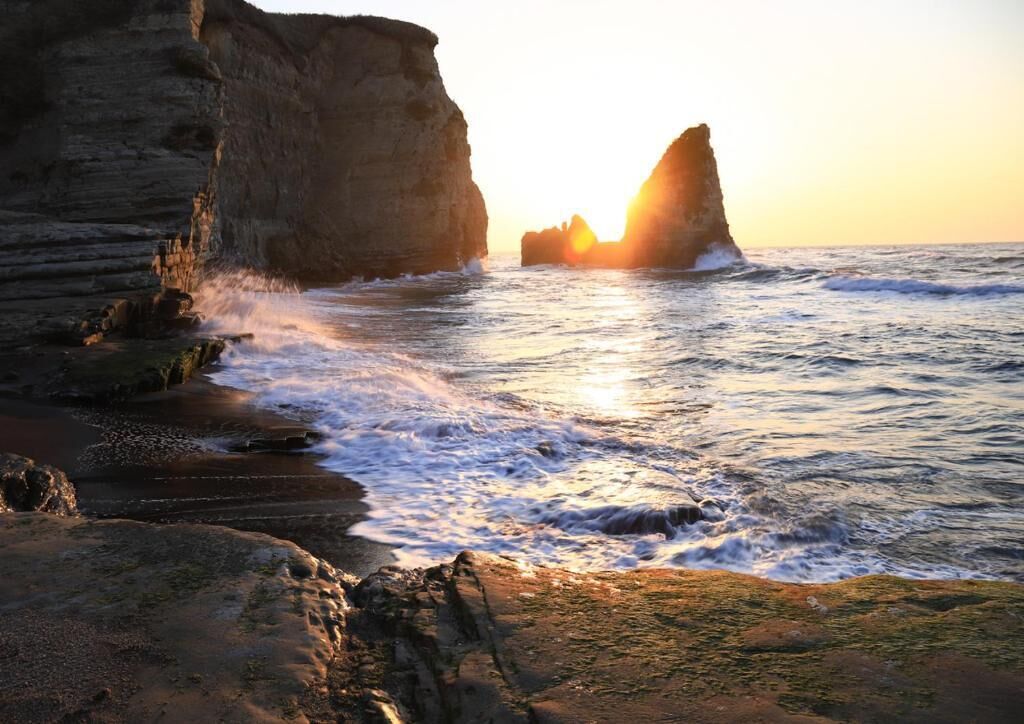 A coastal scene with rocky cliffs and waves.