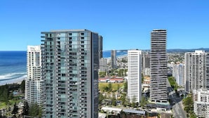 A high-rise building with a modern glass facade, located near a coastline. - Beach Breeze Skyhome at Oracle Level 32 (Gold Coast)