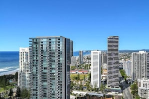 A high-rise building with a modern glass facade, located near a coastline. - Beach Breeze Skyhome at Oracle Level 32 (Gold Coast)