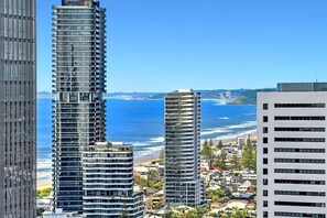 A coastal cityscape with high-rise buildings, a beach, and a clear blue sky. - Beach Breeze Skyhome at Oracle Level 32 (Gold Coast)