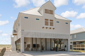 A two-story building with a covered porch, a staircase, and a number '2132' on the side. - Bourbon Bay and Whiskey Lullaby Beachfront, Pool, Pickle Ball Court, Fire Pit and Much More (Grand Isle)