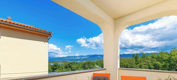Ein Balkon mit Blick auf Berge und Grün.