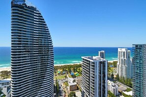 A high-rise hotel with a curved facade overlooking a beach and ocean. - Ocean Luxury Skyhome at Oracle Level 36 (Gold Coast)