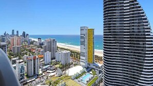 Um hotel moderno com fachada curva, piscina e vista para a praia e o oceano.