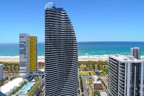 A tall, curved hotel with a pool area and a view of the beach and ocean. - Beach Skyhome at Oracle Level 37 (Gold Coast)