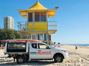 A lifeguard station with a white vehicle parked in front.