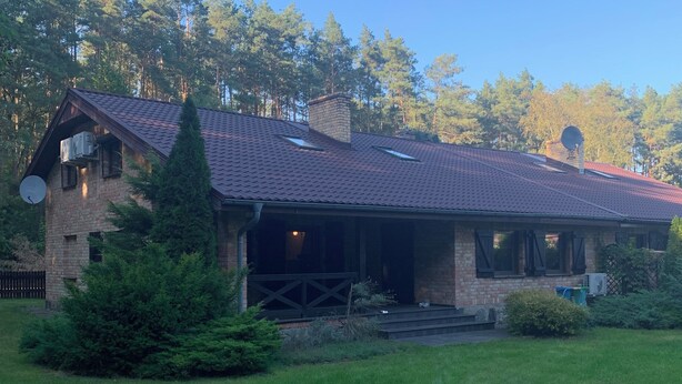 A house with a sloped roof, a chimney, and a satellite dish.