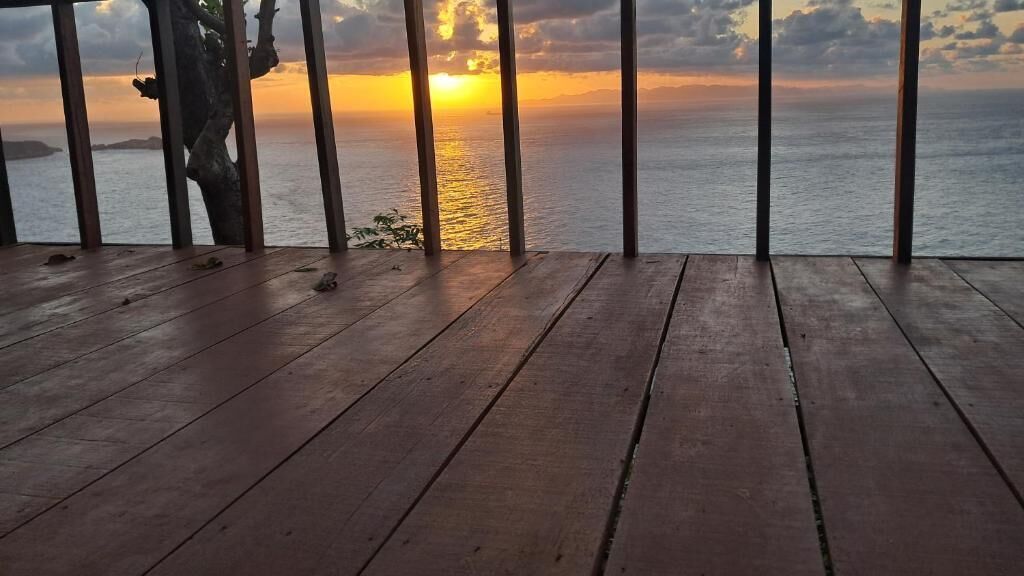 Un pontile di legno con vista sull'oceano al tramonto.