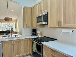 A modern kitchen with wooden cabinets, a built-in microwave, a coffee maker, and a sink. - Saltwater Pool, Walk to Pickleball, North Phoenix Retreat,  Norterra Shopping. (Phoenix)