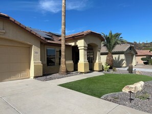 A residential house with a garage, a well-maintained lawn, and a palm tree. - Saltwater Pool, Walk to Pickleball, North Phoenix Retreat,  Norterra Shopping. (Phoenix)