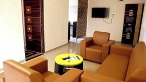 Una sala de estar moderna con un conjunto de sofá, una mesa de centro y un televisor montado en la pared.
