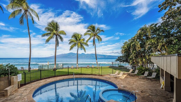 A pool with a view of the ocean and palm trees. - 1BR Condo Near Oceanfront Lawn, Pool & Sunset Views- Paki Maui 212 (Lahaina)