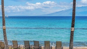 A beach with chairs and a view of the ocean. - 1BR Condo Near Oceanfront Lawn, Pool & Sunset Views- Paki Maui 212 (Lahaina)