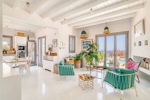 A spacious living area with a kitchen, dining table, and seating area. - Villa La Magnifique - The best view (Naousa)