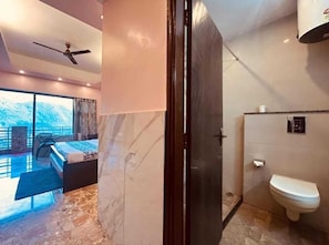 Ein modernes Hotelzimmer mit Bett, Bad und Balkon mit Blick.
