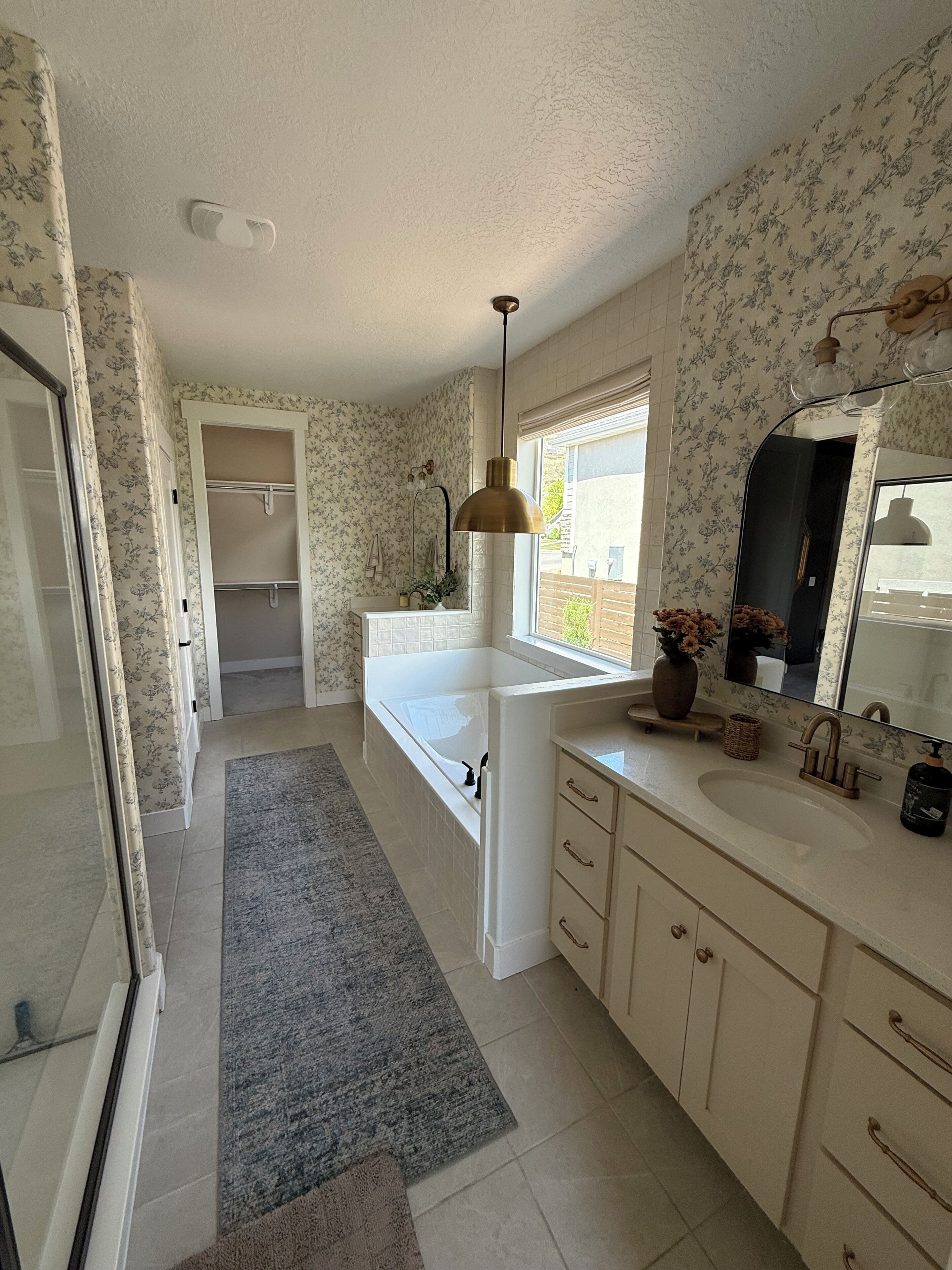 A bathroom with a bathtub, a shower, a sink, and a mirror.
