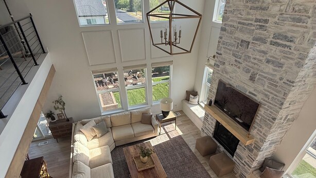 Amplia sala de estar con un sofá modular grande, una chimenea y vistas al exterior.