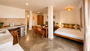 A compact hotel room with a kitchenette, a dining area, and a bed. - Samsara - Villa Cappucino (Koh Rong)
