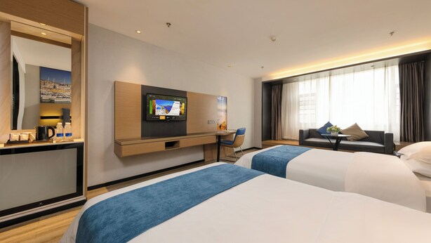 A hotel room with two beds, a TV, a desk with a chair, and a large window with curtains. - Yasite Hotel Yuyuan Road Metro Station (Kunming)