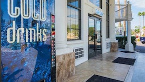 A hotel entrance with a 'COLD DRINKS' sign, large windows, and a covered outdoor area. - 2 Queen Beds | Smoking (Chandler)