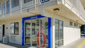 A building entrance with a blue 'welcome' sign, large glass windows, and a number '6' sign. - 1 Full Bed|Mobility Access Tub| NS (Thornton)