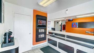 A reception area with a counter, a television mounted on the wall, and a door.