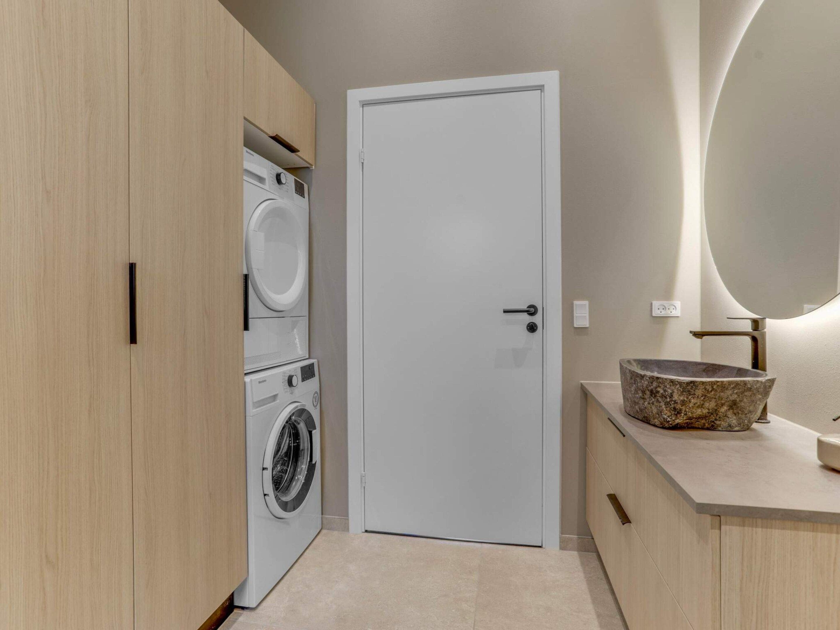 A laundry room with a washing machine, dryer, and a door.