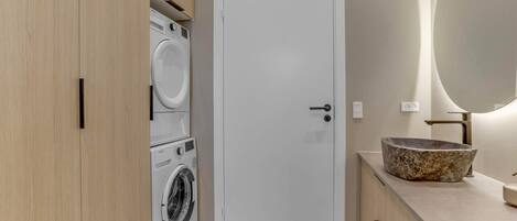A laundry room with a washing machine, dryer, and a door.