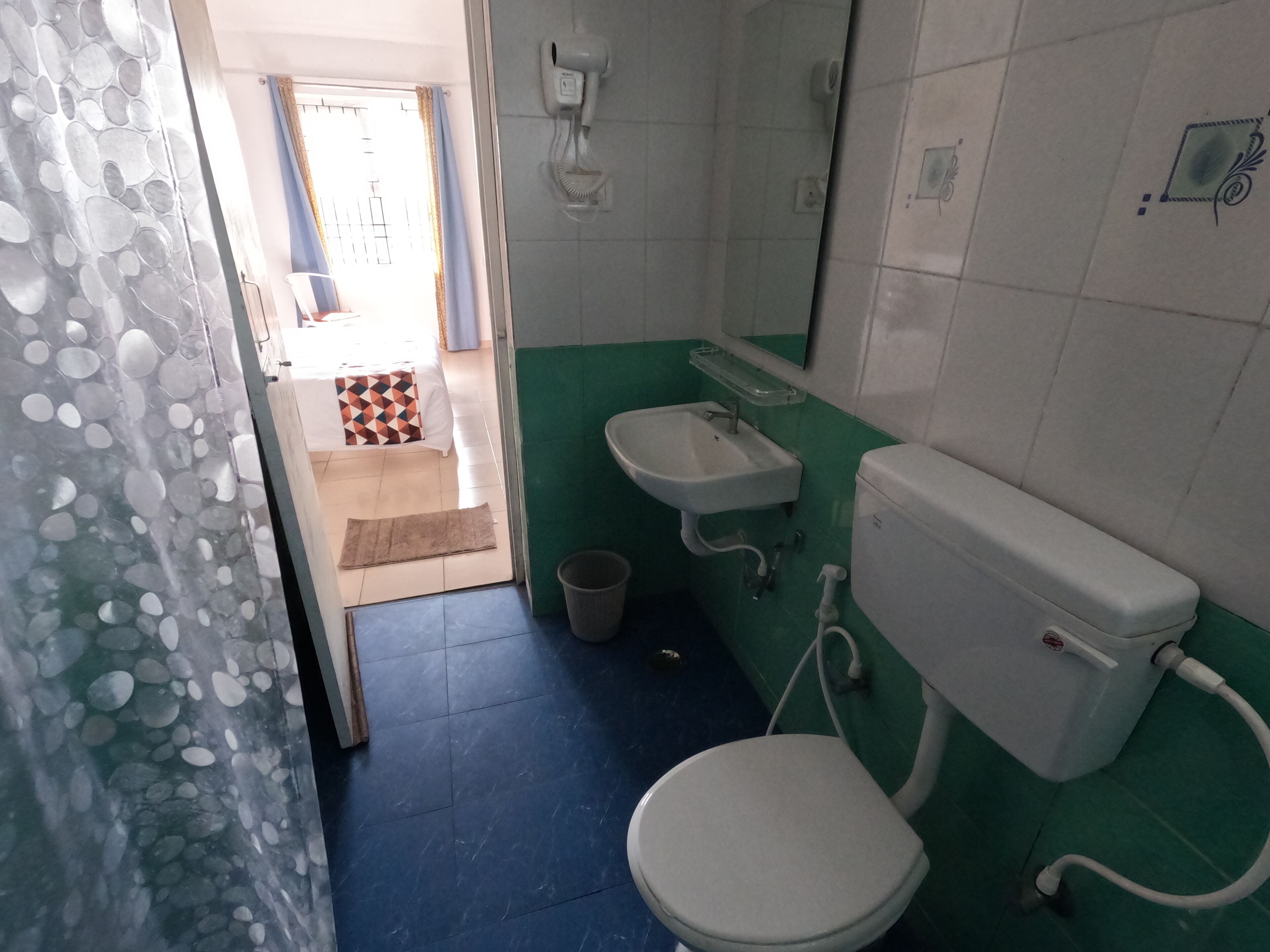 Une salle de bain comprenant des toilettes, un lavabo et un espace douche.