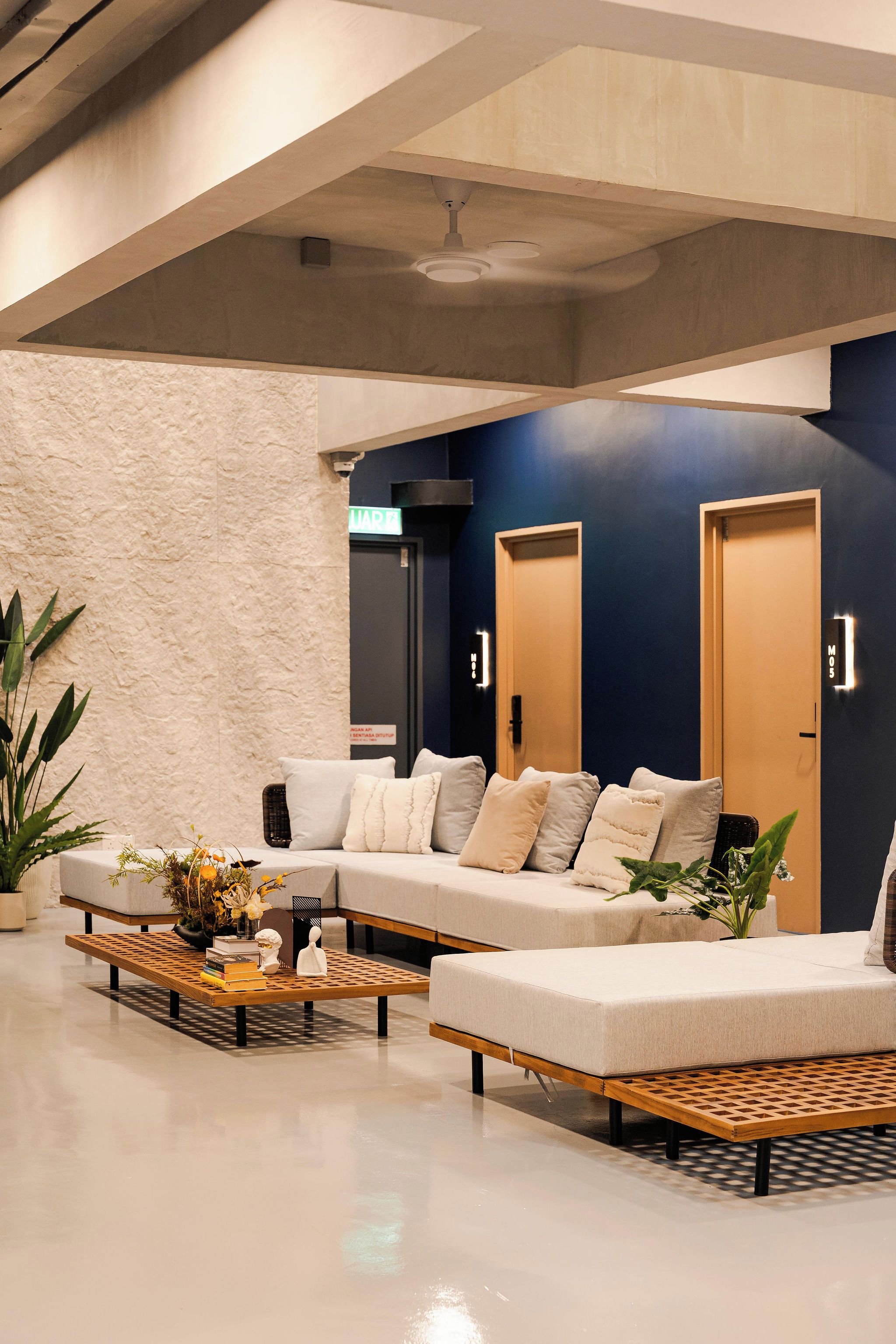 A modern lobby with a sectional sofa, a coffee table, and a reception desk.