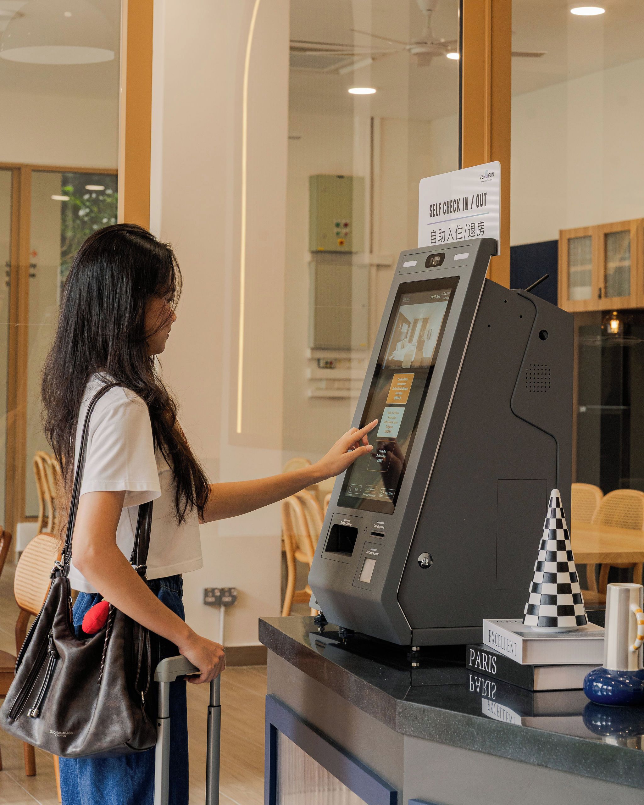Una mujer usando un quiosco de autoservicio en el vestíbulo de un hotel.