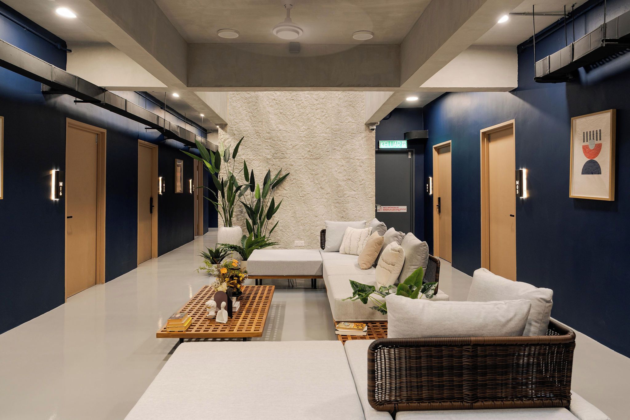 Um saguão de hotel moderno com uma recepção, área de estar e uma grande planta.