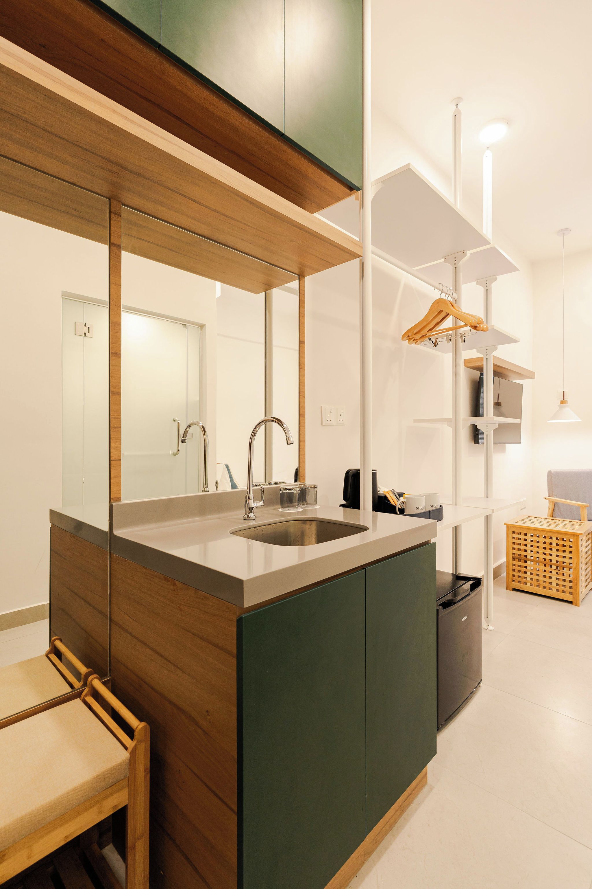 A modern bathroom with a wooden vanity, a large mirror, a sink, and a built-in cabinet.
