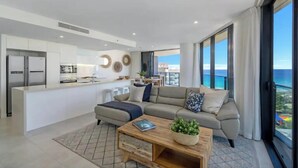 A modern living room with a sofa, coffee table, and a view of the ocean. - Beach Haven at Oracle Level 14 (Gold Coast City)