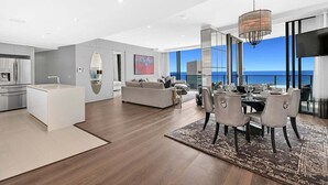 Ein modernes Interieur mit Essbereich, Küche und Wohnbereich, mit einem großen Fenster und Blick.
