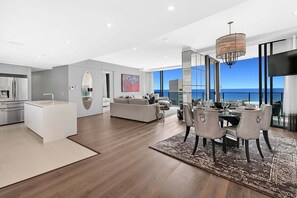 Ein modernes Interieur mit Essbereich, Küche und Wohnbereich, mit einem großen Fenster und Blick.