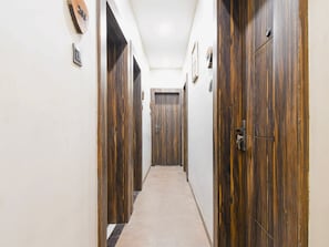 Un couloir avec des portes en bois et une moquette de couleur claire.