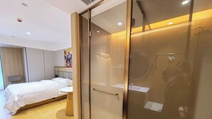 A hotel room with a bed, bedside table, and a glass-enclosed shower area. - Kunming Fish Inn City Center Nanping Street Branch (Kunming)