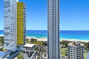 A high-rise hotel with multiple floors, a parking area, and a view of the beach. - Beach Sunrise at Oracle Level 21 (Gold Coast City)