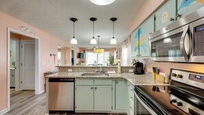 A kitchen with a dishwasher, stove, microwave, and cabinets. - Tee Times, Poolside Vibes! Myrtle Beach Retreat (Myrtle Beach)