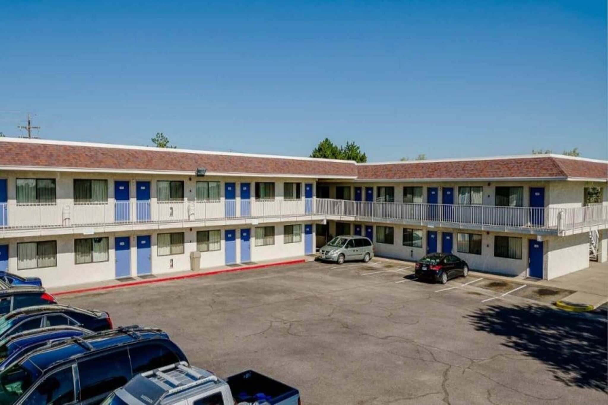 A motel with multiple rooms, a parking lot, and a small outdoor area.