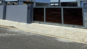 Ein modernes, zweistöckiges Gebäude mit Garage, Balkon und blauem Himmel.