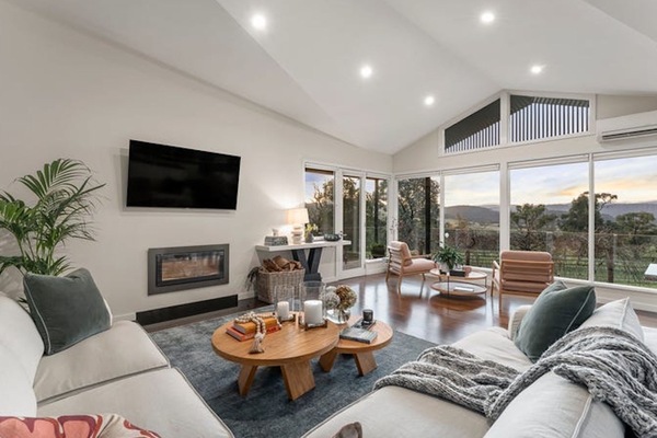 Spacious open-plan living area with a cosy fireplace and sweeping countryside outlook.