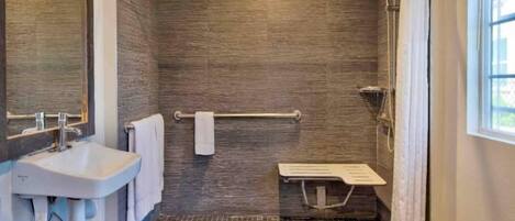 Un baño moderno con lavamanos, toallero, ducha y ventana.