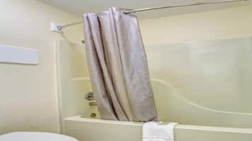 A bathroom with a bathtub, toilet, and a towel rack.