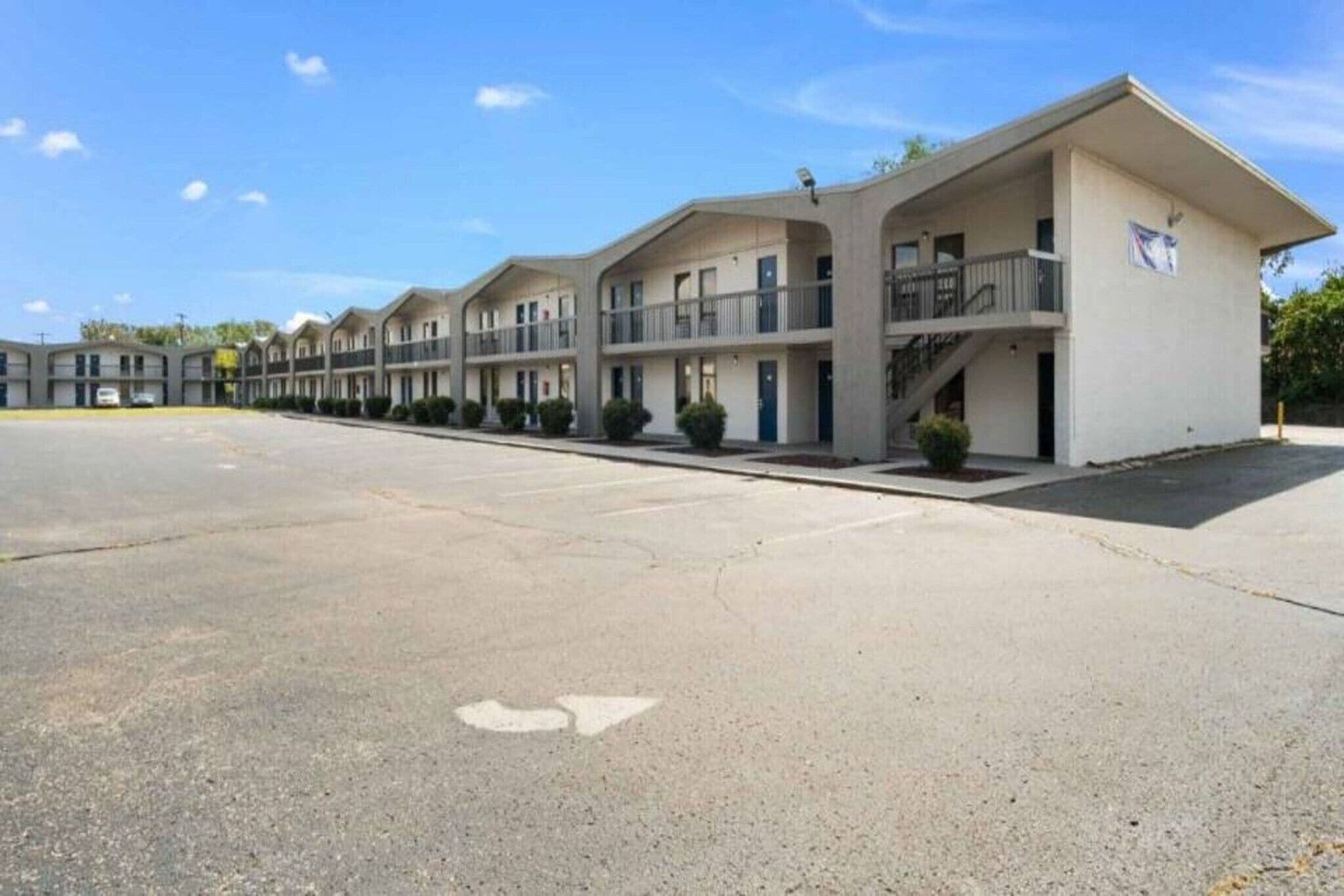 Un motel con varios edificios de dos pisos, cada uno con balcones y una escalera central.