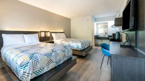 A hotel room with two beds, a desk, a chair, a TV, and a bathroom visible in the background. - 2 Full Beds|Mobil Acc|RI Shower|Nsmk (Charlotte NC)